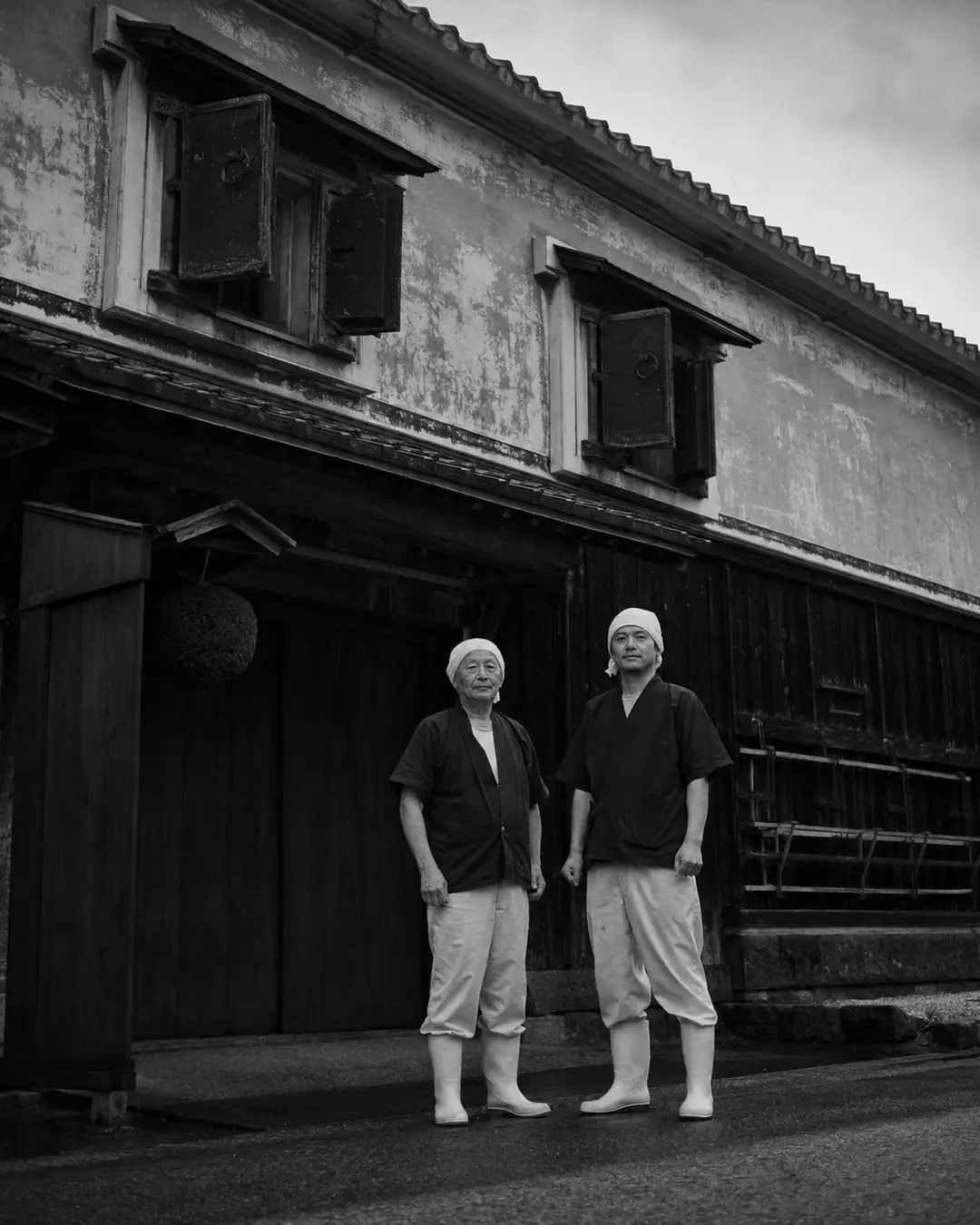 Two brewers standing in front of the brewery