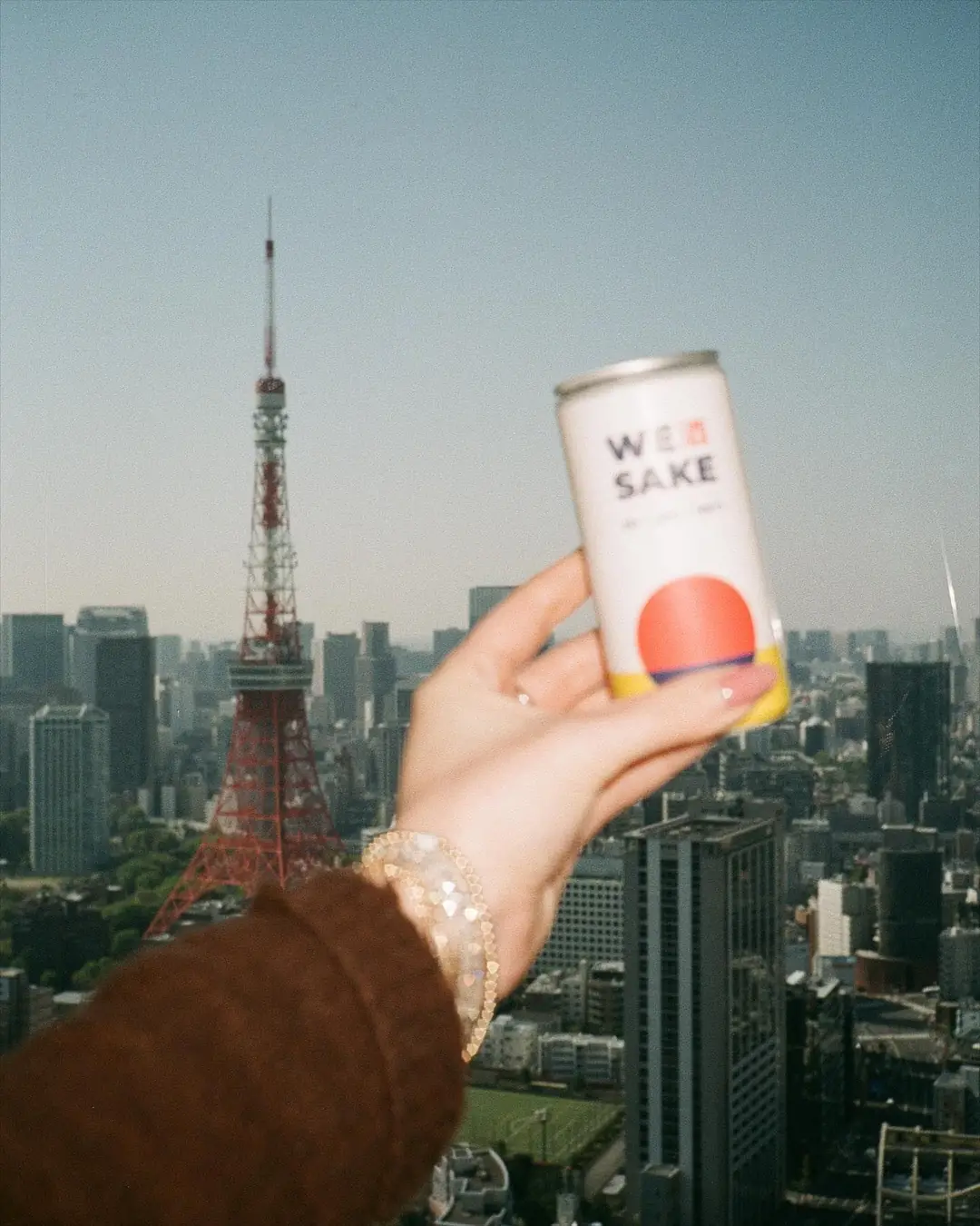 A WESAKE can held up in front of Tokyo Tower
